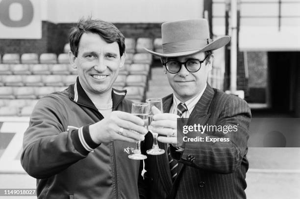 English singer, songwriter, pianist, and composer Elton John, chairman of Watford FC, celebrating with Watford FC manager Graham Taylor ahead of the...