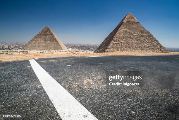 road past the giza pyramid complex near cairo, egypt - limestone pyramids stock pictures, royalty-free photos & images