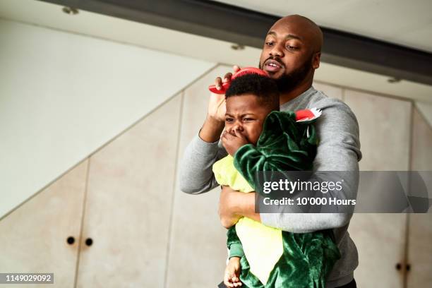 father struggling to brush son's hair - black man cries stock pictures, royalty-free photos & images