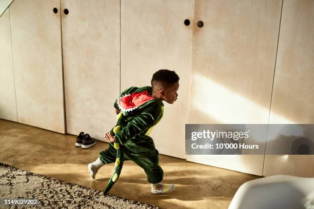 toddler running through house in dragon costume - toddlers playing stock pictures, royalty-free photos & images