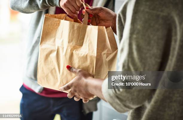 close up of woman receiving take away food delivery - dienste stock-fotos und bilder