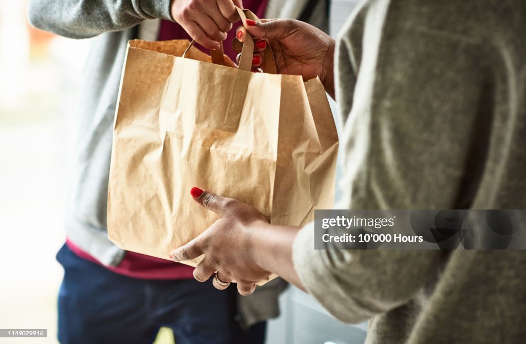 Close up of woman receiving take away food delivery