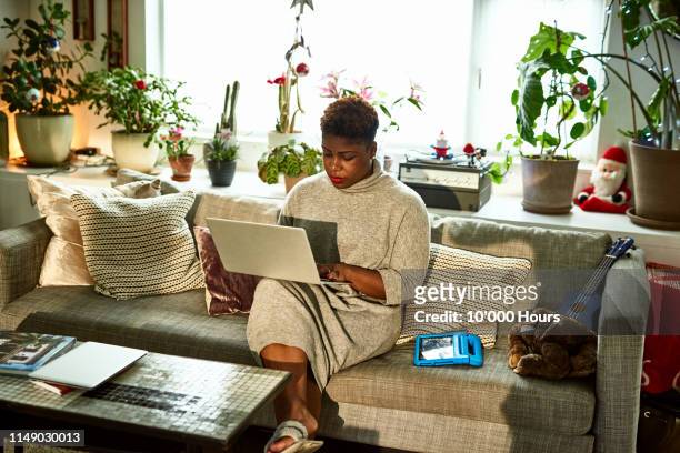 Woman working from home on sofa with laptop