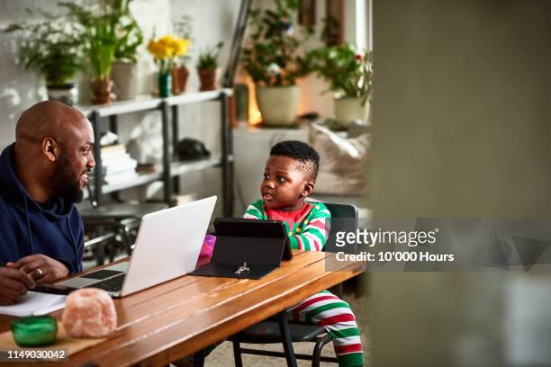 father and toddler at table with laptop and tablet - working from home kids stock pictures, royalty-free photos & images