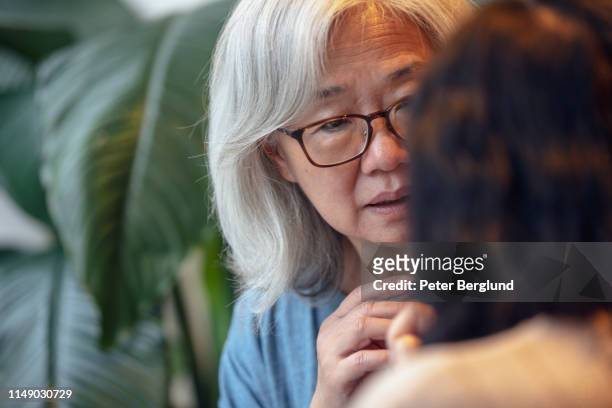 twee senior dames praten - asian couple arguing stockfoto's en -beelden