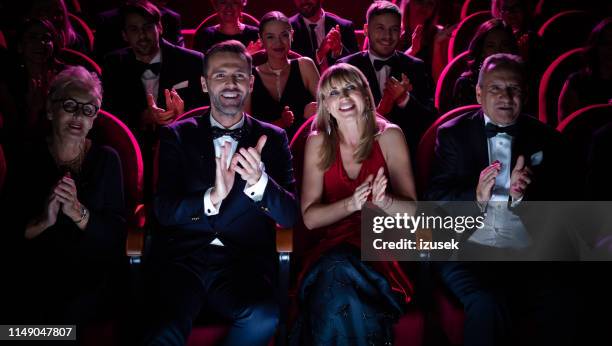 bella coppia che applaude mentre guarda l'opera - orchestra sinfonica foto e immagini stock