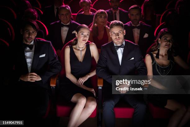 beautiful couple watching theatrical performance - movie in tuxedo stock pictures, royalty-free photos & images