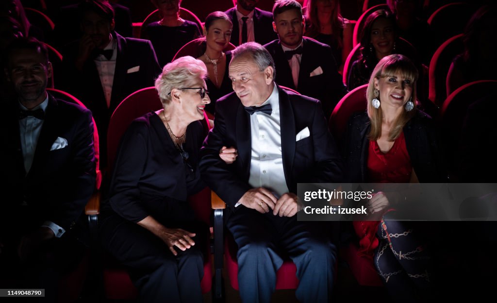 Pareja de ancianos hablando mientras están sentados en el teatro