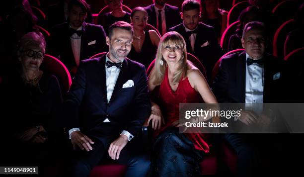 elegante pareja madura viendo la película en el cine - spotlight film fotografías e imágenes de stock