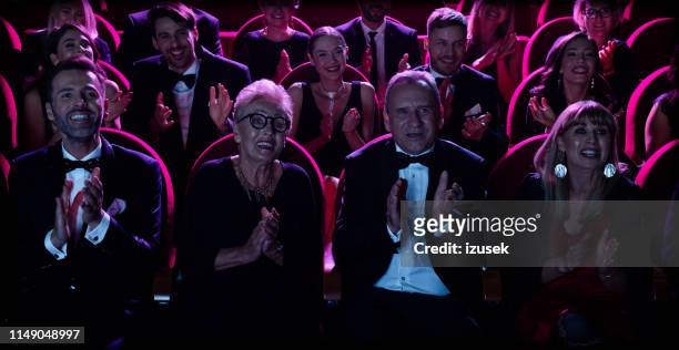 excited audience clapping in opera house - british film reception inside stock pictures, royalty-free photos & images