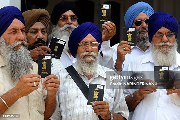 Indian Sikh pilgrims pose with their passports outside the office of The Shiromani Gurdwara Parbandhak Committee at The Golden Temple in Amritsar on...