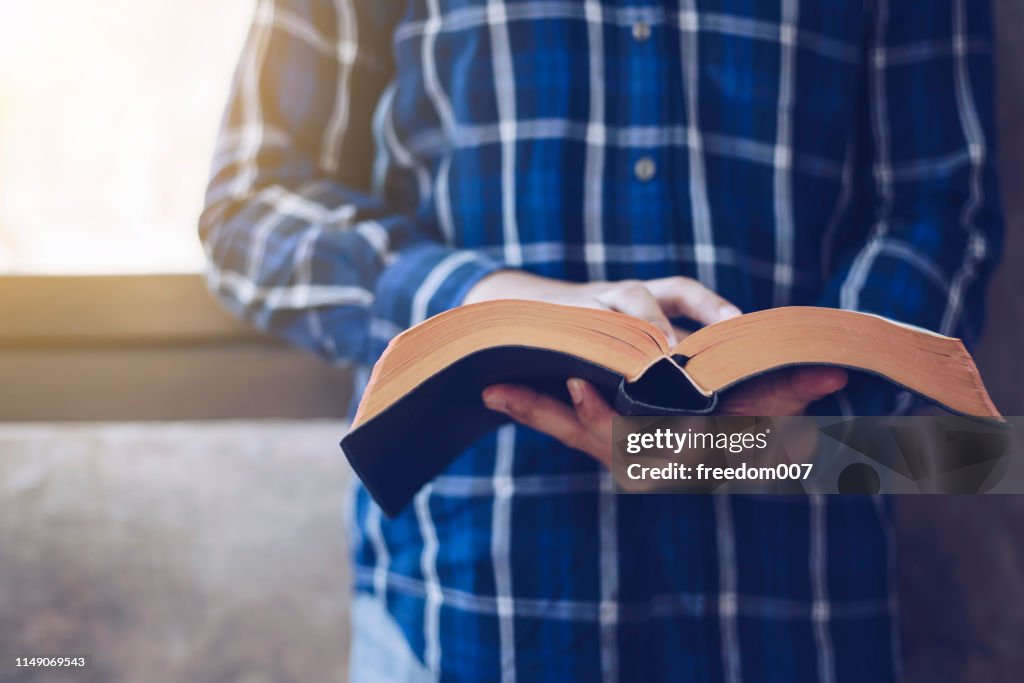 Joven hombre cristiano leyendo la Biblia