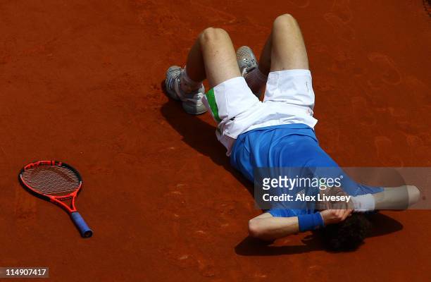 Andy Murray of Great Britain grimaces as he lies on the floor after injuring his foot during the men's singles round three match between Andy Murray...