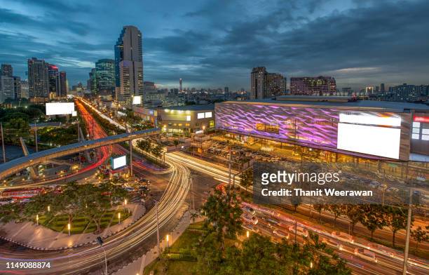 night view of traffic light with business building at ratchadapisek road in bangkok thailand. - road light trail stock pictures, royalty-free photos & images