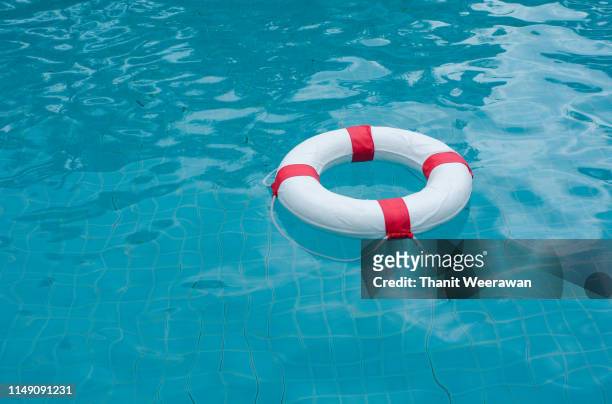 life preserver, life buoy floating in a clear pool water - float photos et images de collection