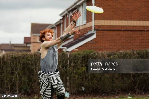 man fänscht frisbee - frisbee stock-fotos und bilder