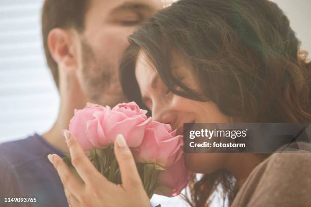 frau genießt moment mit ihrem mann, nachdem sie rosen erhalten hat - woman giving flowers stock-fotos und bilder