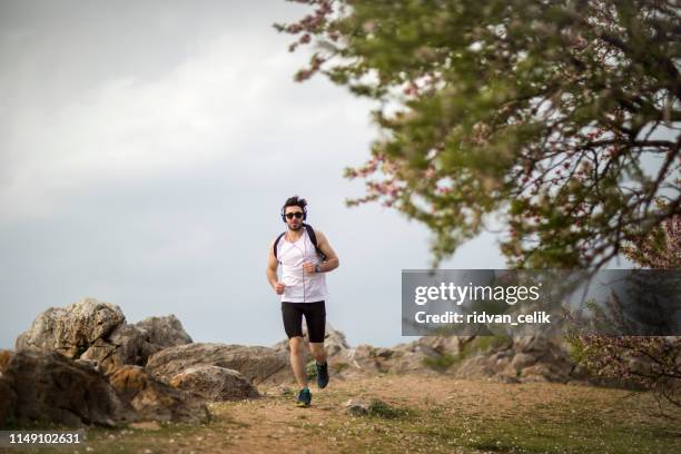 man trail running on a path in the mountain - chamonix train stock pictures, royalty-free photos & images