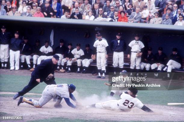 Felipe Alou of the San Francisco Giants slides home as catcher John Roseboro of the Los Angeles Dodgers misses the tag during an MLB game on May 21,...