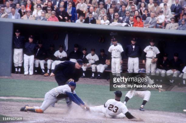 Felipe Alou of the San Francisco Giants slides home as catcher John Roseboro of the Los Angeles Dodgers misses the tag during an MLB game on May 21,...