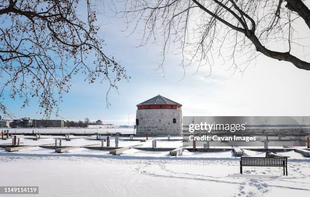 martello tower and docks on the waterfront of kingston on a snowy day. - martello tower stockfoto's en -beelden