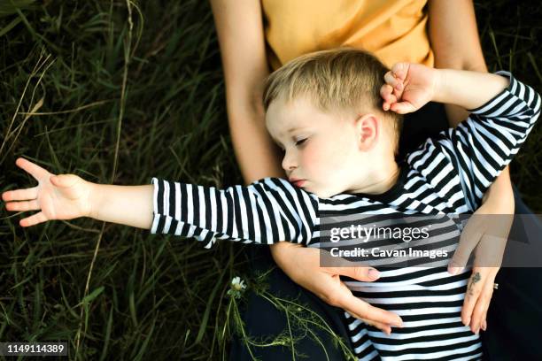 portrait of a mother and boy lying outdoor. - baby eltern von oben stock-fotos und bilder