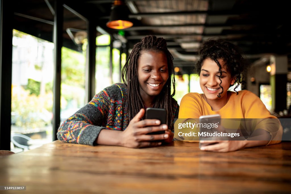 Zwei Millenial-Freunde mit Handy.