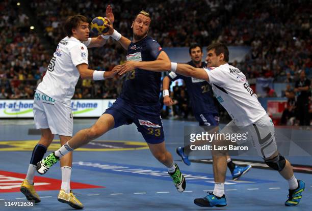 Pascal Hens of Hamburg is challenged by Jonas Kaellmann and Julen Aguinagalde of Ciudad Real during the EHF Final Four semi final match between...