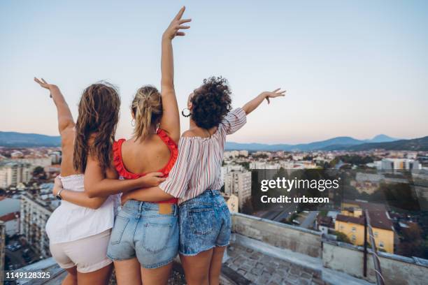 three women on the rooftop - woman shorts stock pictures, royalty-free photos & images