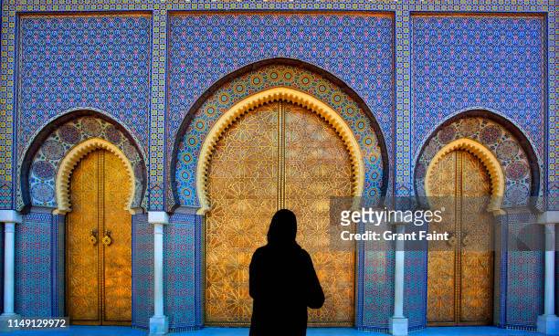 woman standing at brass doors. - fez marruecos fotografías e imágenes de stock