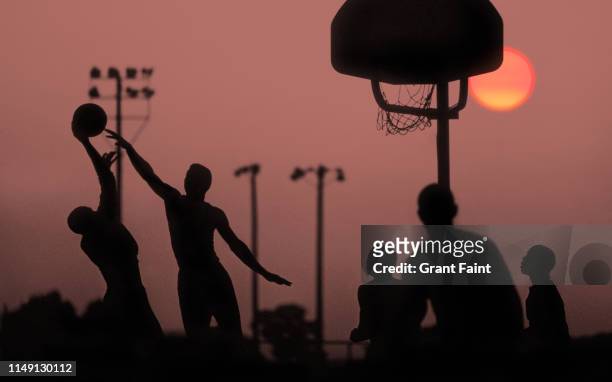 young men playing basketball at sunset. - blocking sports activity stock pictures, royalty-free photos & images