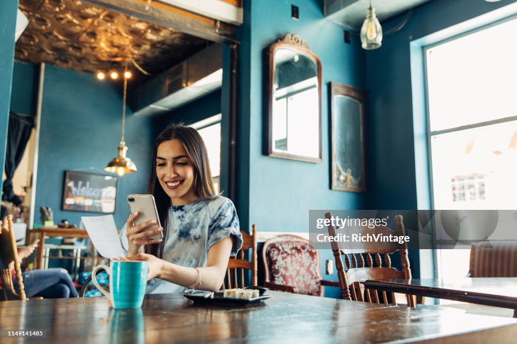 Hispanic Woman Tracking Restaurant Bill