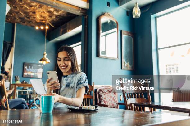 hispanic woman tracking restaurant bill - frugality stock pictures, royalty-free photos & images