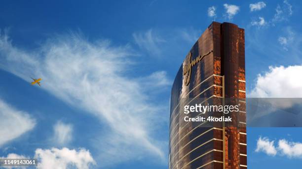 wynn las vegas with commercial jet flying by - wynn las vegas stock pictures, royalty-free photos & images