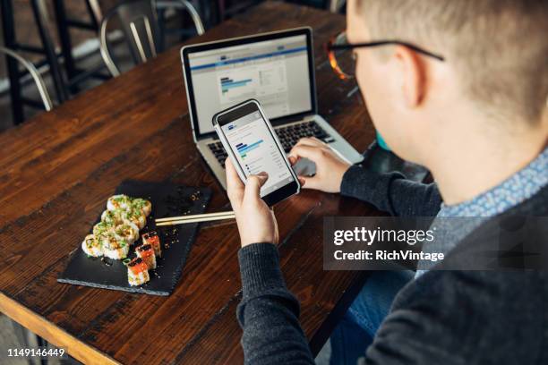 millennial checking finances on smart phone - personal banking stock pictures, royalty-free photos & images