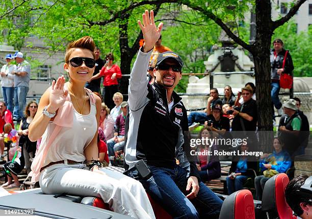 Alex Tagliani of Canada driver of the Sam Schmidt Motorsports Dallara Honda with his wife Bronte during the parade for the 100th Anniversary of the...