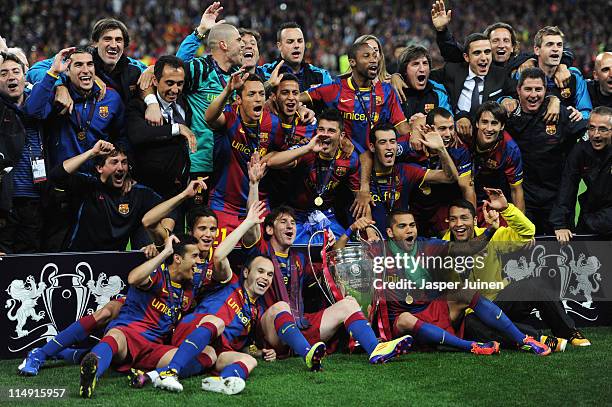 Lionel Messi and Daniel Alves of Barcelona hold the trophy as the team pose for photographs after victory in the UEFA Champions League final between...