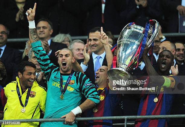 Prince Felipe Of Spain applauds as Eric Abidal of FC Barcelona lifts the trophy and celebrates with teammates after victory in the UEFA Champions...