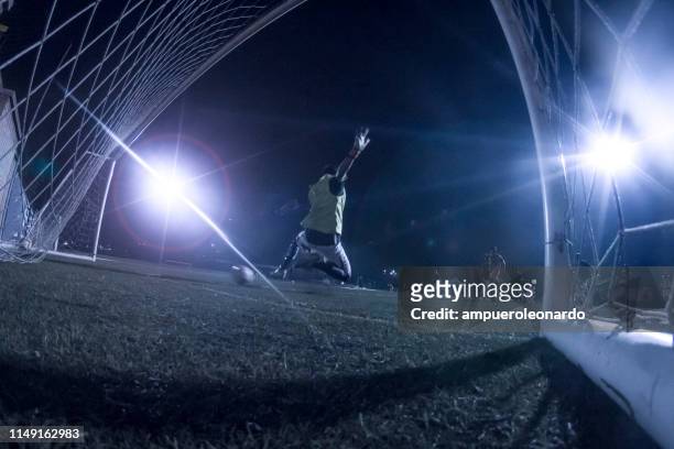 goalkeeper kicks the ball in a night stadium - shootout stock pictures, royalty-free photos & images