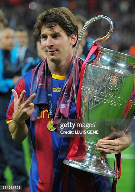Barcelona's Argentinian forward Lionel Messi celebrates with the trophy at the end of the UEFA Champions League final football match FC Barcelona vs....