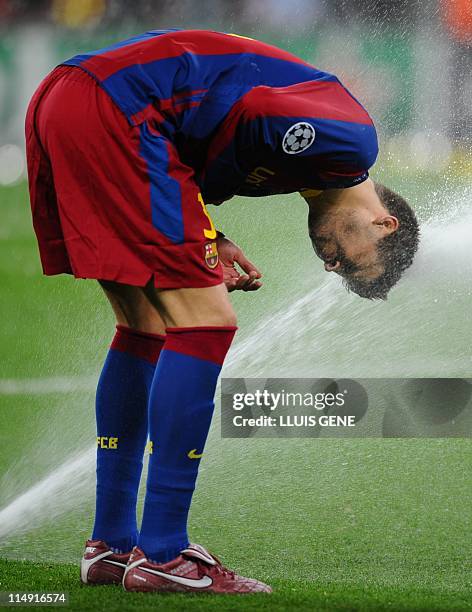 Barcelona's Spanish defender Gerard Pique plays with a water spray at the end of the UEFA Champions League final football match FC Barcelona vs....