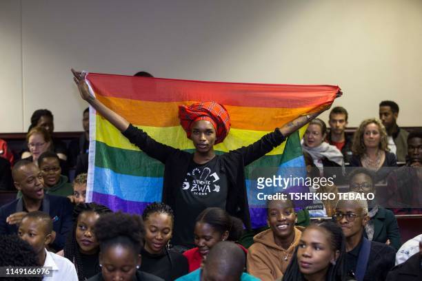 An activist holds up a rainbow flag to celebrate inside Botswana High Court in Gaborone on June 11, 2019. - Botswana's Court ruled on June 11 in...