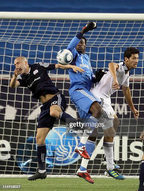 Donovan Ricketts of the Los Angeles Galaxy stops a shot as teammate Omar Gonzalez and Rajko Lekic of the New England Revolution collide and on May...