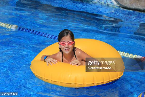 ung flicka simma i poolen med uppblåsbar ring - tube girl bildbanksfoton och bilder