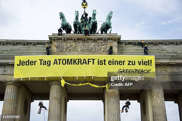 Greenpeace activists unfurl a banner against nuclear power from the top of landmark Brandenburg Gate in Berlin on May 29, 2011. A group of anti...
