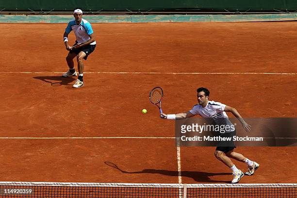 Daniele Bracciali of Italy hits a forehand next to team mate Potito Starace of Italy during the men's doubles round three match between Stephen Huss...