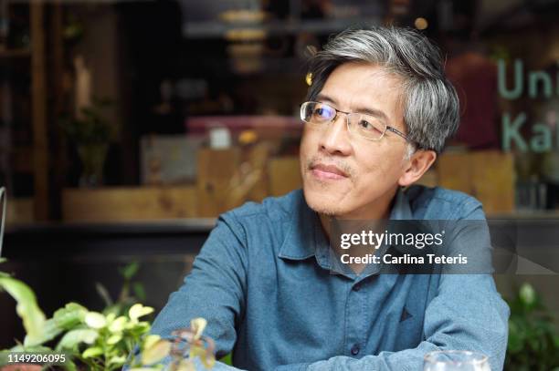 senior chinese man outside a cafe - elderly chinese man stock pictures, royalty-free photos & images