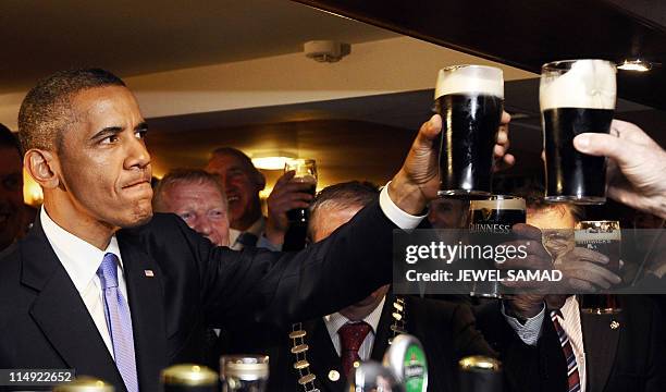 President Barack Obama rises his glass of Guinness in a pub as he visits Moneygall village in rural County Offaly, Ireland, where his...