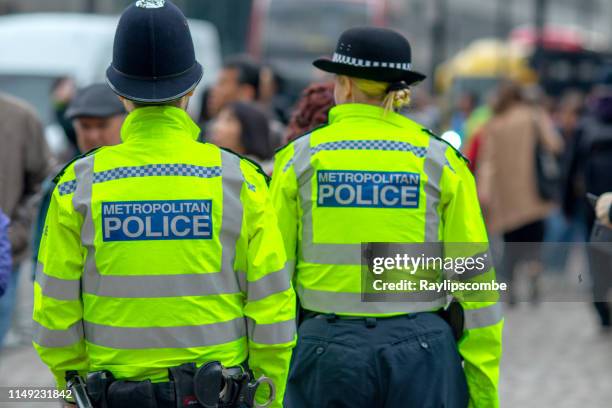 metropolitan policeman and policewoman in high vis jackets looking at crowds in westminster, central london - bobby stock pictures, royalty-free photos & images