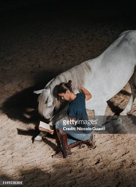 October 8: French 'rejoneadora' Lea Vicens is photographed for Self Assignment while reading a book with one of her horses at 'Rancho El Rocio' on...